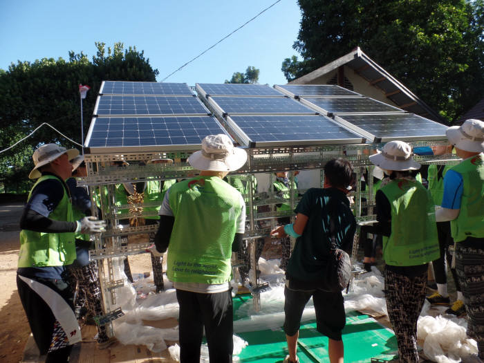 한전 대학생 해외봉사단원들이 인도네시아 툼박마을 진입로에 가로등 태양광을 설치하고 있다.