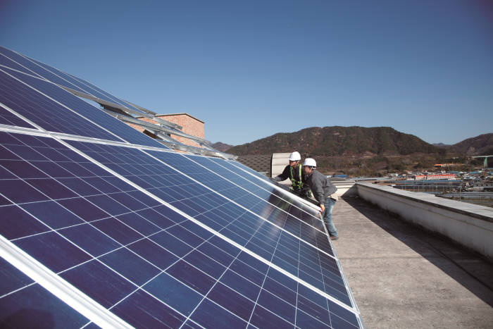 한화그룹 직원들이 복지시설 옥상에 태양광 발전설비를 설치하고 있다. [자료:한화그룹]