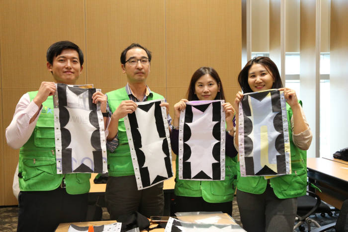 포스코대우 직원들이 폐현수막으로 제작한 나무내복을 들어보였다. [자료:포스코대우]