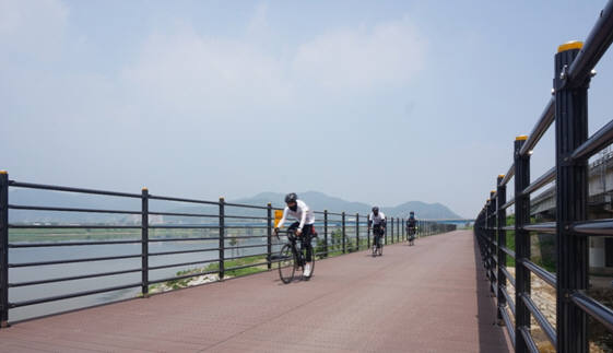 SK케미칼 에코젠이 적용된 목재플라스틱 복합재 자전거 도로 위를 자전거가 달리고 있다. [자료:SK케미칼]
