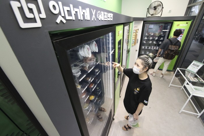 KT 기가에너지 매니저 프랜차이즈 플러스가 적용된 서울 마곡나루의 '잇다가게'에서 고객들이 자판기를 이용해 비대면으로 반찬을 구매하고 있다(제공:KT)