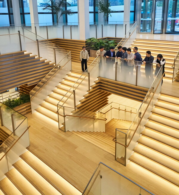 LG 직원들이 LG트윈타워 저층부 공용공간 ‘커넥트윈’에서 대화를 나누고 있다. ‘커넥트윈’의 대형 계단은 1층 로비와 지하 1층을 연결하며, 이동과 휴식의 기능을 결합한 독특한 구조를 갖추고 있다. [사진 LG]